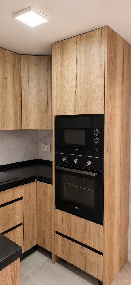 Zona de cocción con horno negro y muebles EGGER Halifax Natural