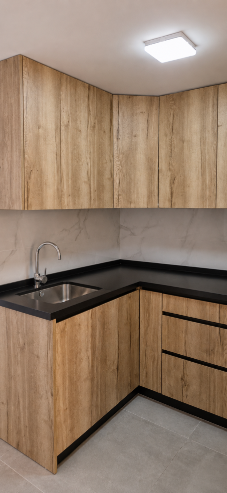 Detalle de cocina en L con puertas EGGER Halifax Natural y uñero negro